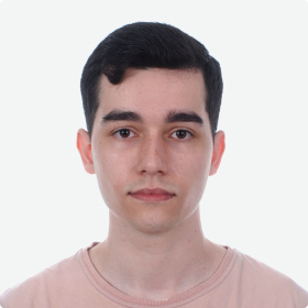 Profile photo of a young man with short hair and a neutral expression, wearing a light pink T-shirt, with a light background.